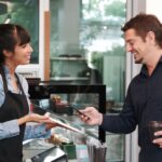 Image of a customer using a POS system to pay for his coffee