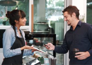 Image of a customer using a POS system to pay for his coffee