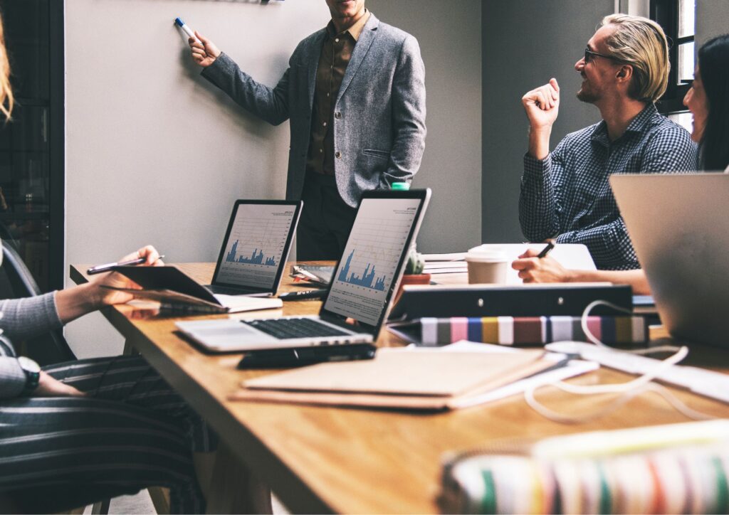 Image of an office meeting using management systems to track data