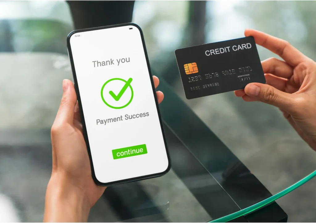 Image of a woman using her credit card at a business to make a mobile payment