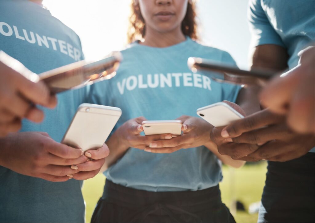 Image of one of our fundraising ideas with volunteers on their phones while participating in a social media contest.