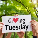 Image of people holding up a sign that says "Giving Tuesday"