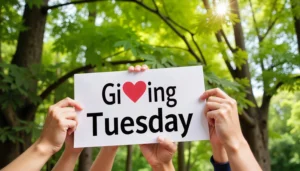 Image of people holding up a sign that says "Giving Tuesday"